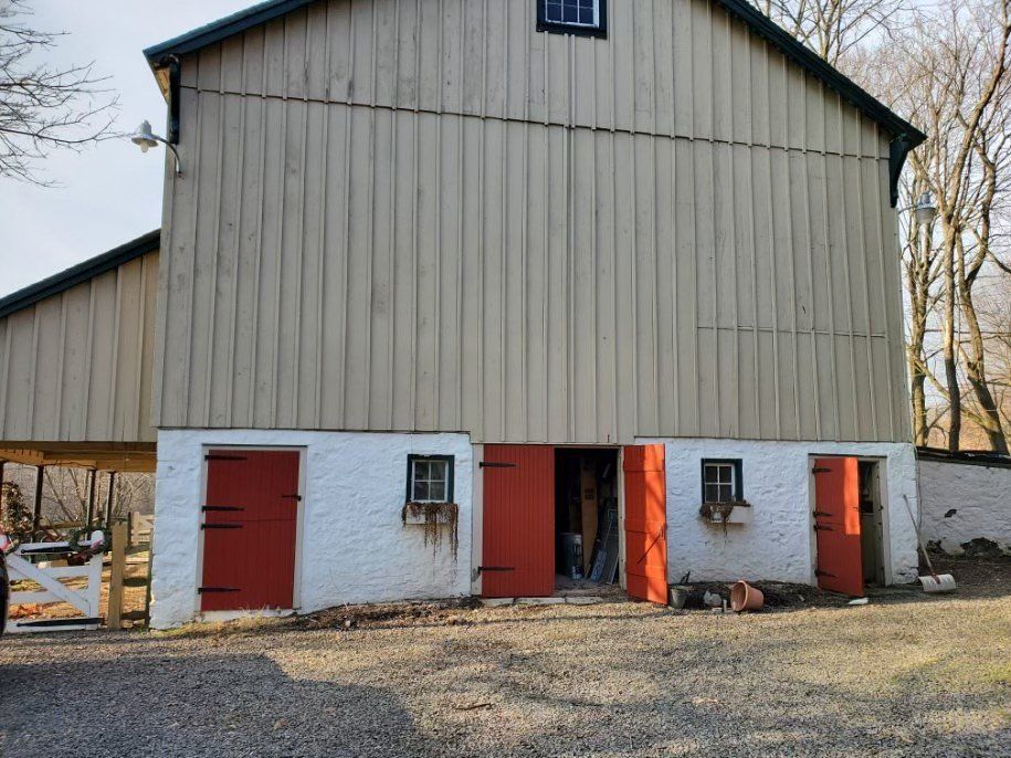 A white barn with red doors and windows