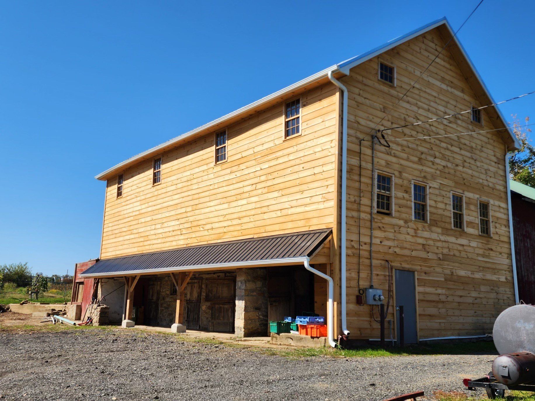 A large wooden barn with a blue sky in the background.