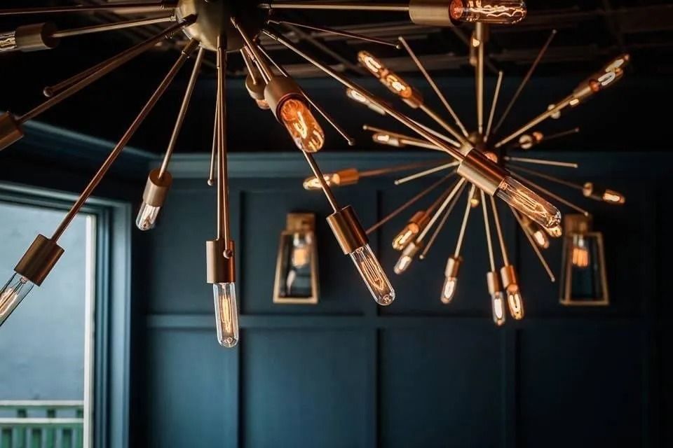 Gold and glass light fixtures against dark blue wall.
