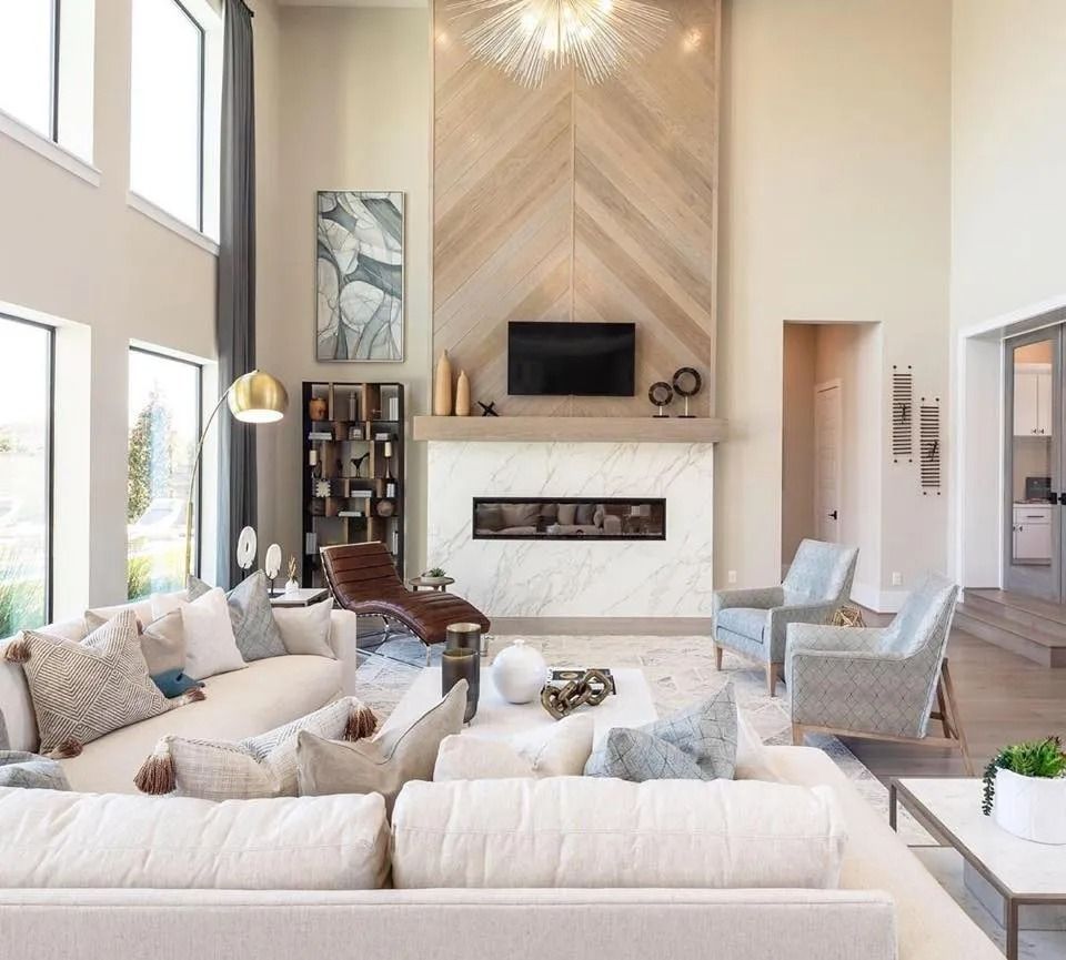 Spacious living room with high ceilings, fireplace, and contemporary furniture in light neutral tones.