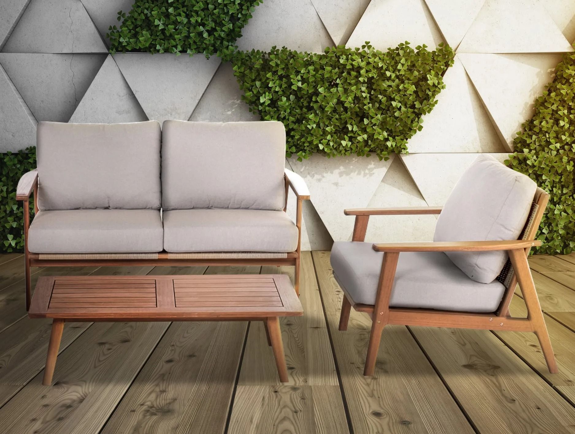 Outdoor furniture set: loveseat, armchair, and coffee table on a wooden deck, with a green wall backdrop.