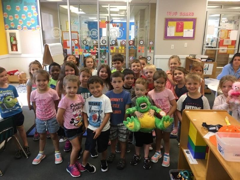 A group of children are posing for a picture in a classroom.
