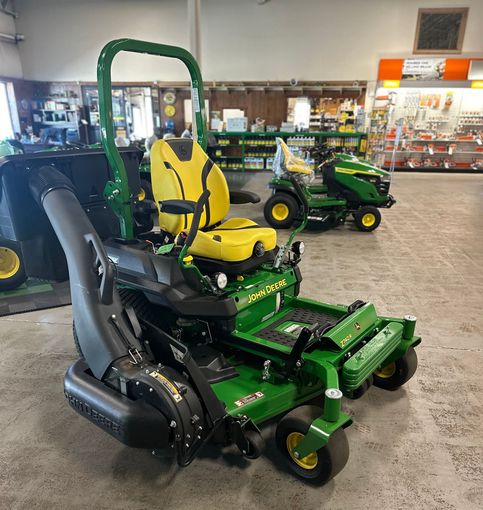 A green john deere lawn mower is parked in a store