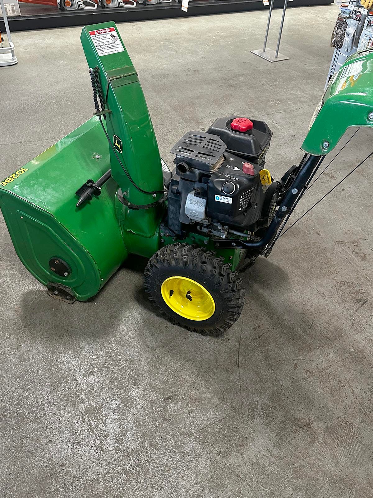 A green and yellow snowblower