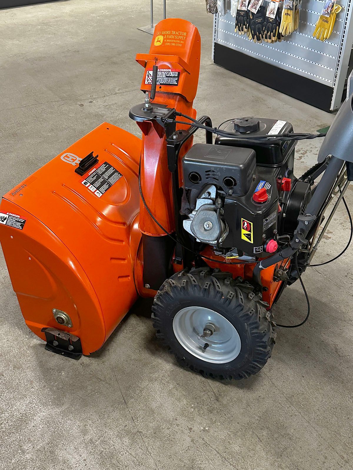 Side view of an orange Husqvarna 18530HV snowblower
