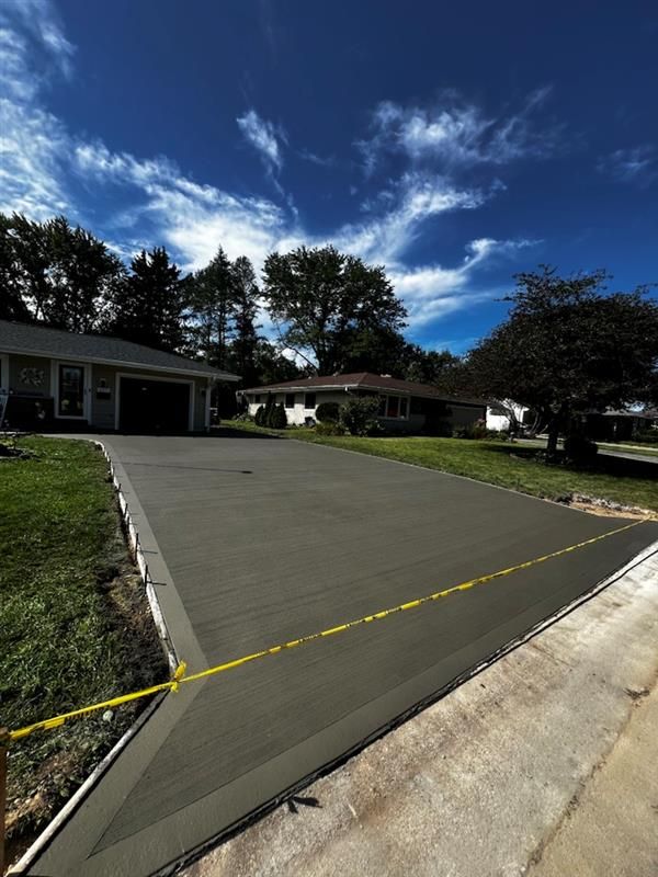 A concrete driveway is being built in front of a house
