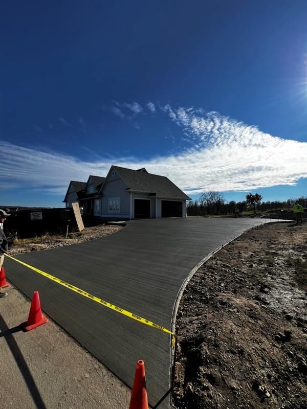A concrete driveway is being built in front of a house.