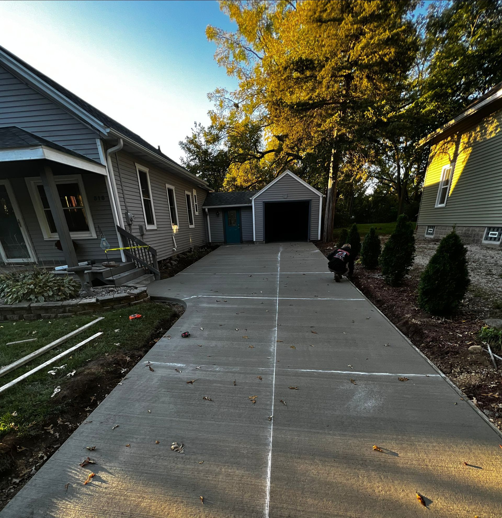A concrete driveway leading to a house with a garage