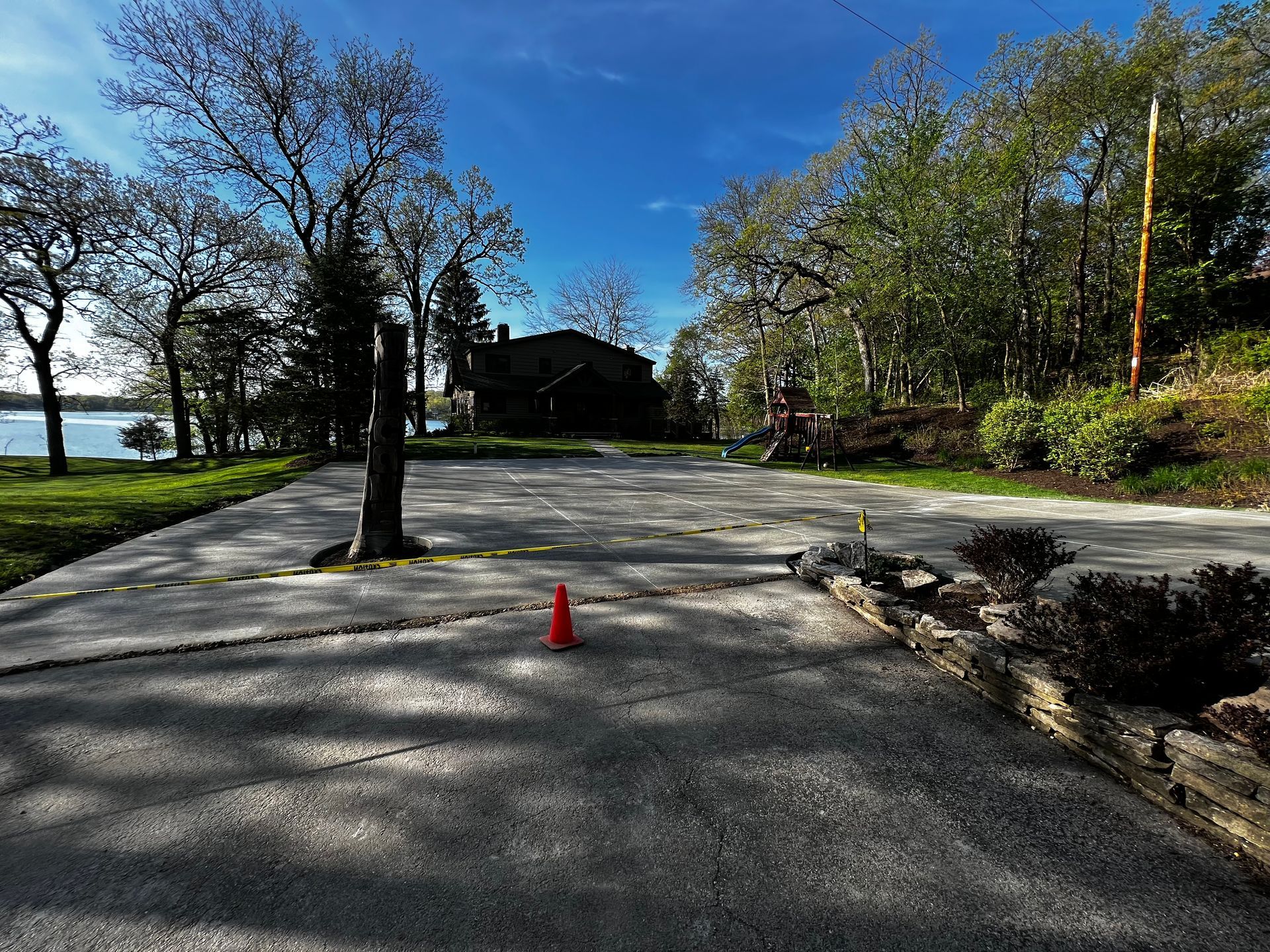 A concrete driveway with a red cone in the middle of it.