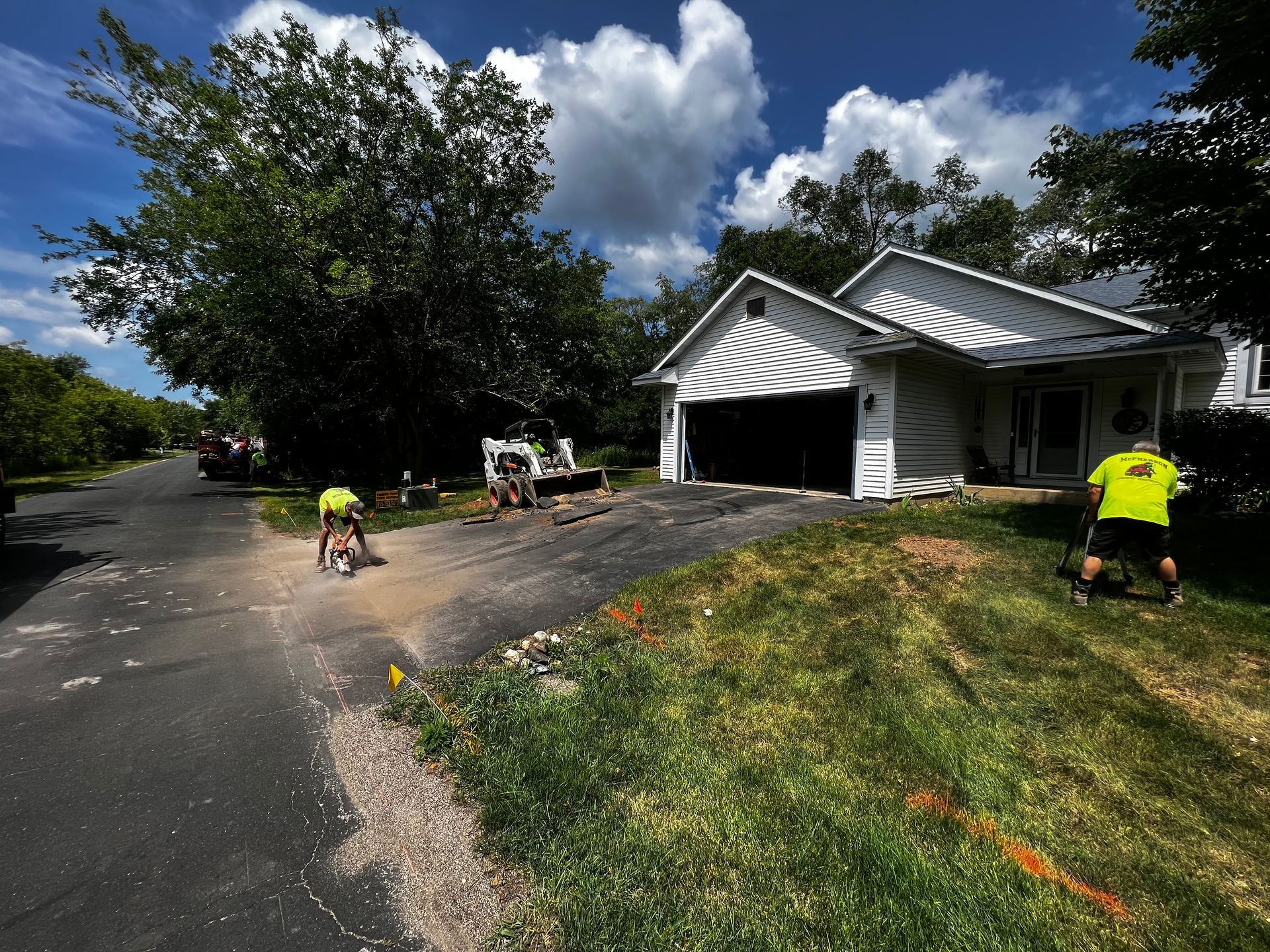 A man in a yellow shirt is standing in front of a house