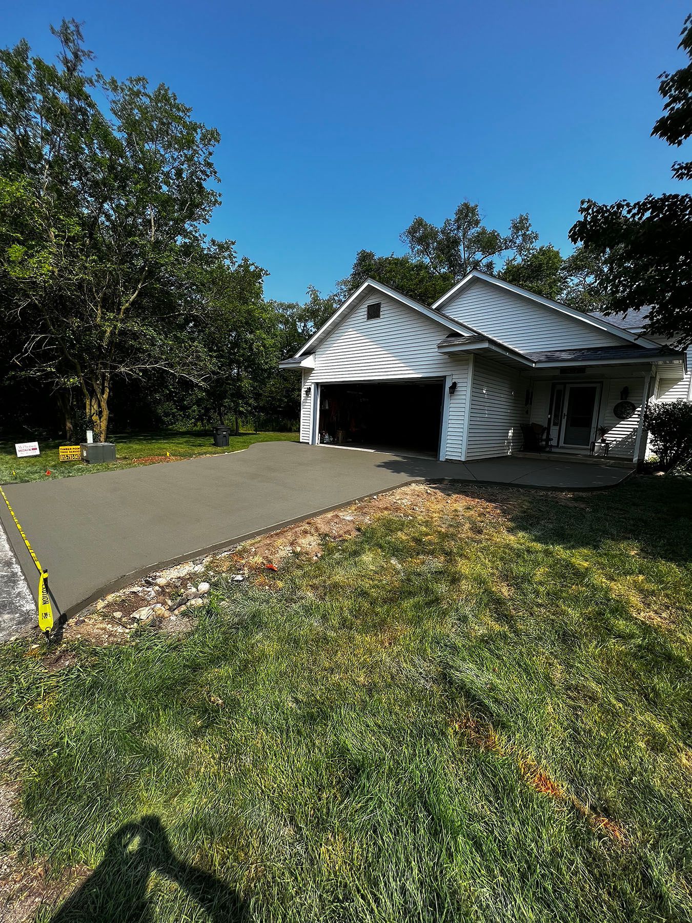 A white house with a concrete driveway in front of it.