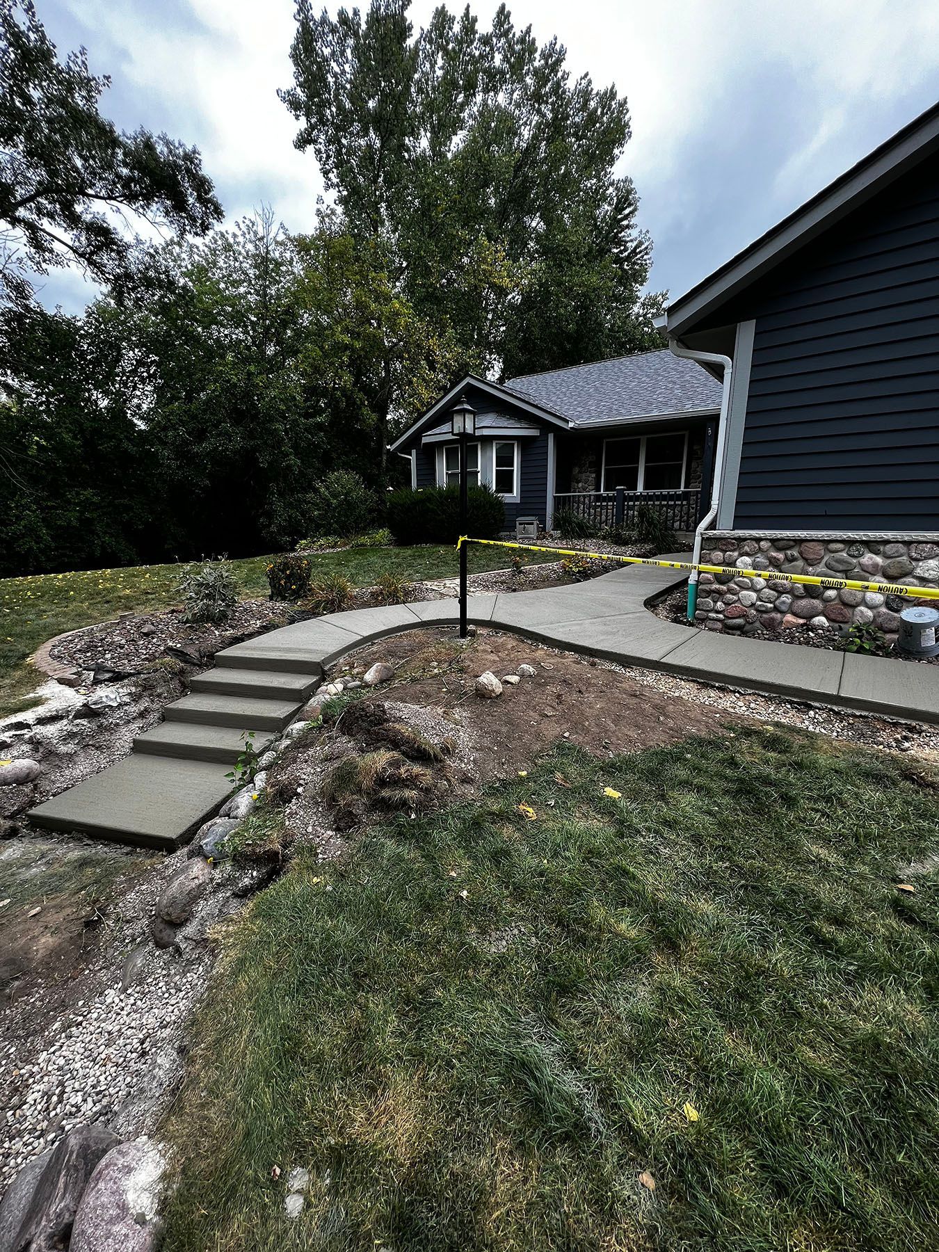 A concrete walkway is being built in front of a house.