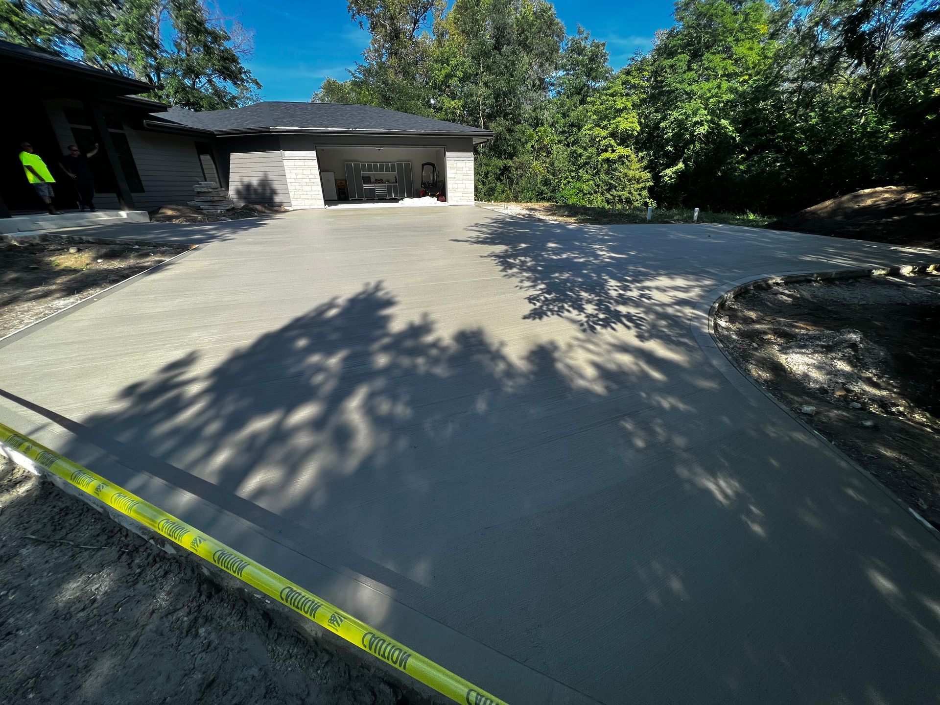 A concrete driveway is being built in front of a house.