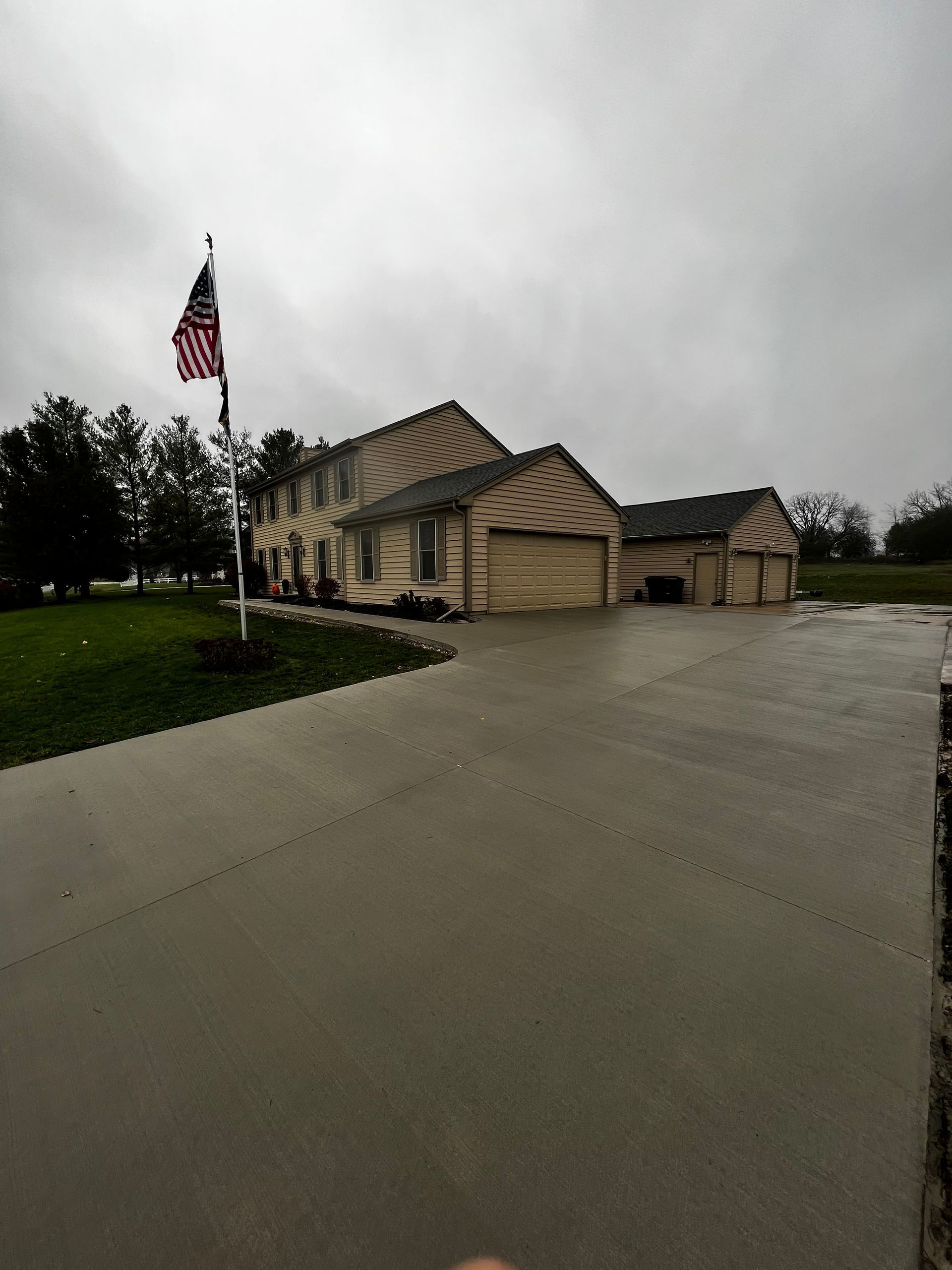 A house with a flag in front of it on a cloudy day