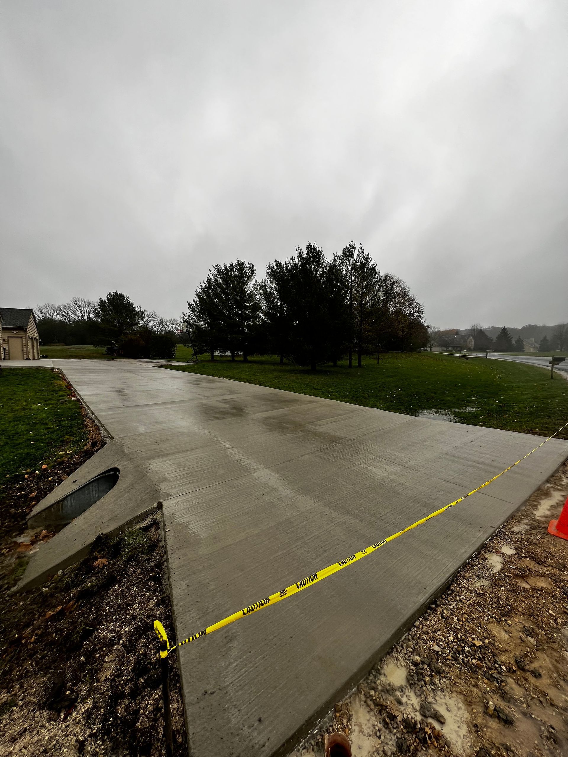 A concrete driveway with a yellow tape on it