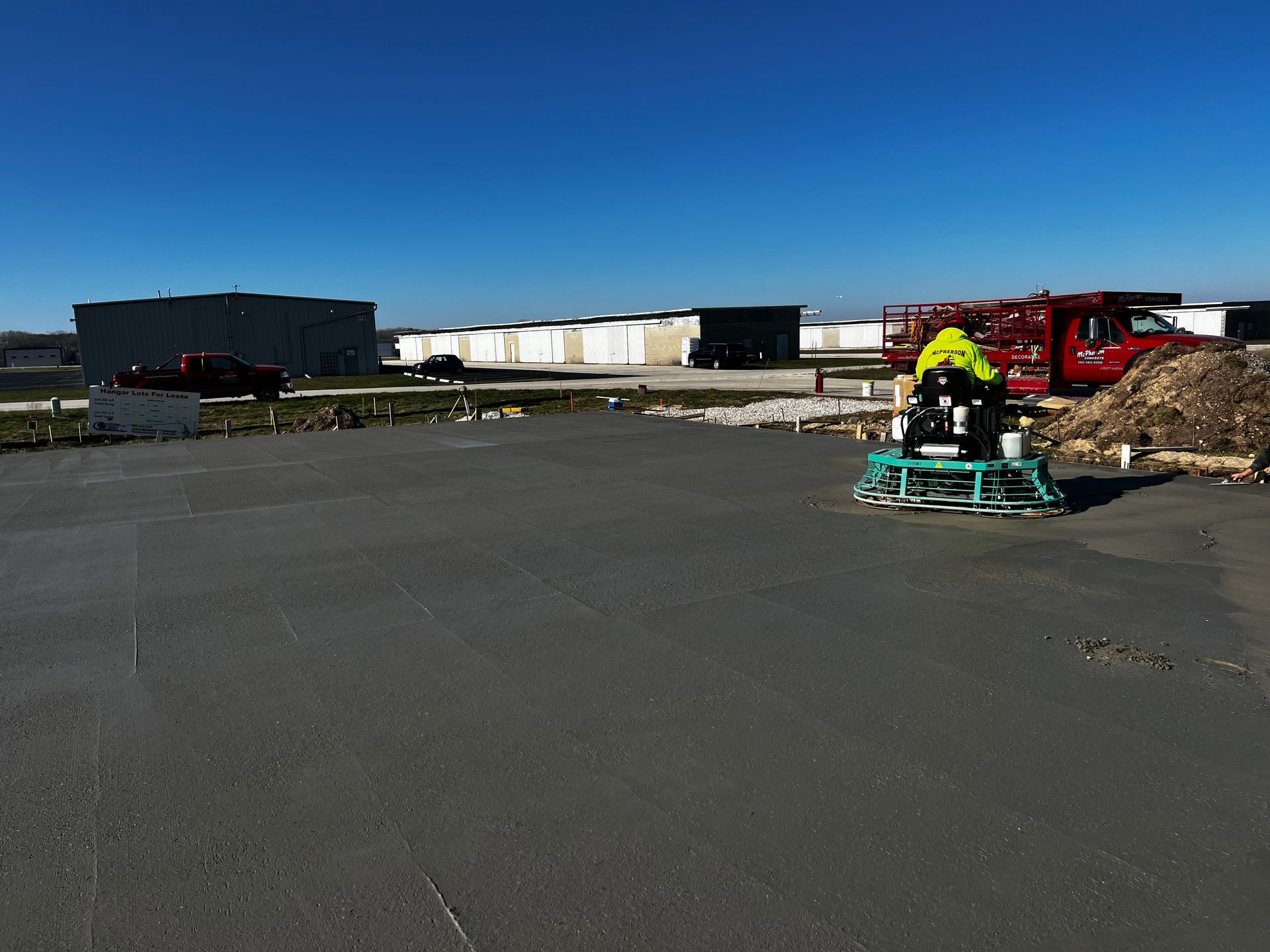 A man is working on a machine in a parking lot