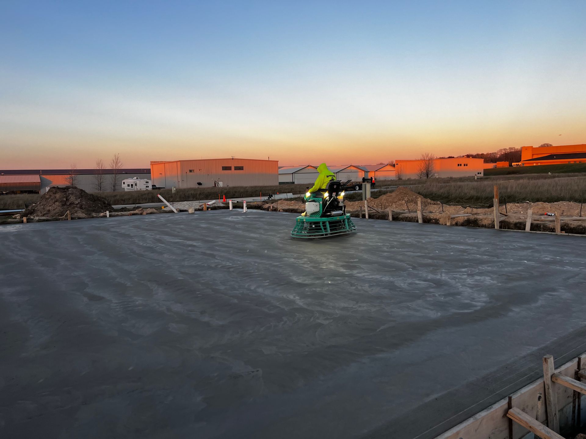 A construction worker is using a machine to level a concrete floor.