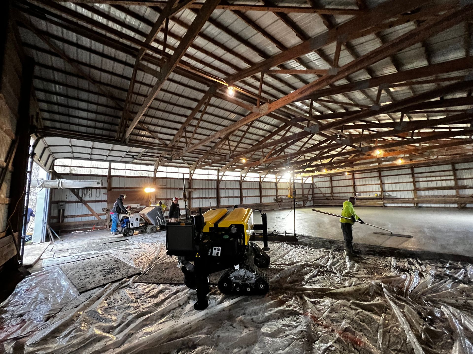 A group of people are working inside of a barn.