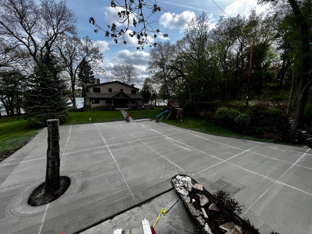 A large concrete driveway with a house in the background