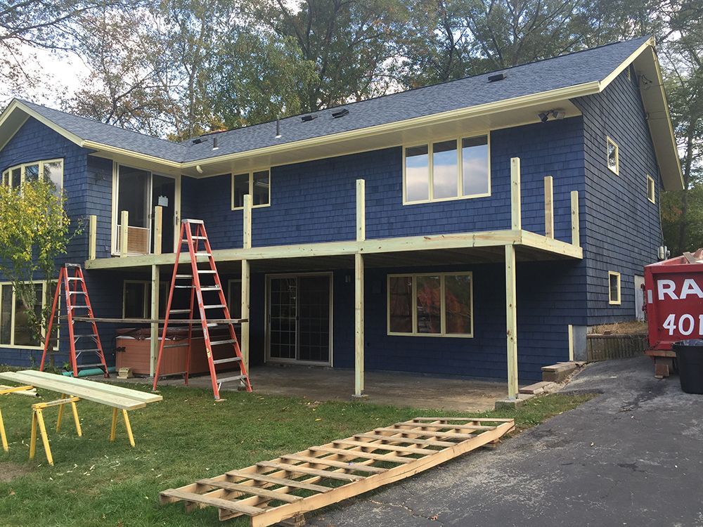 A blue house with a red truck parked in front of it.