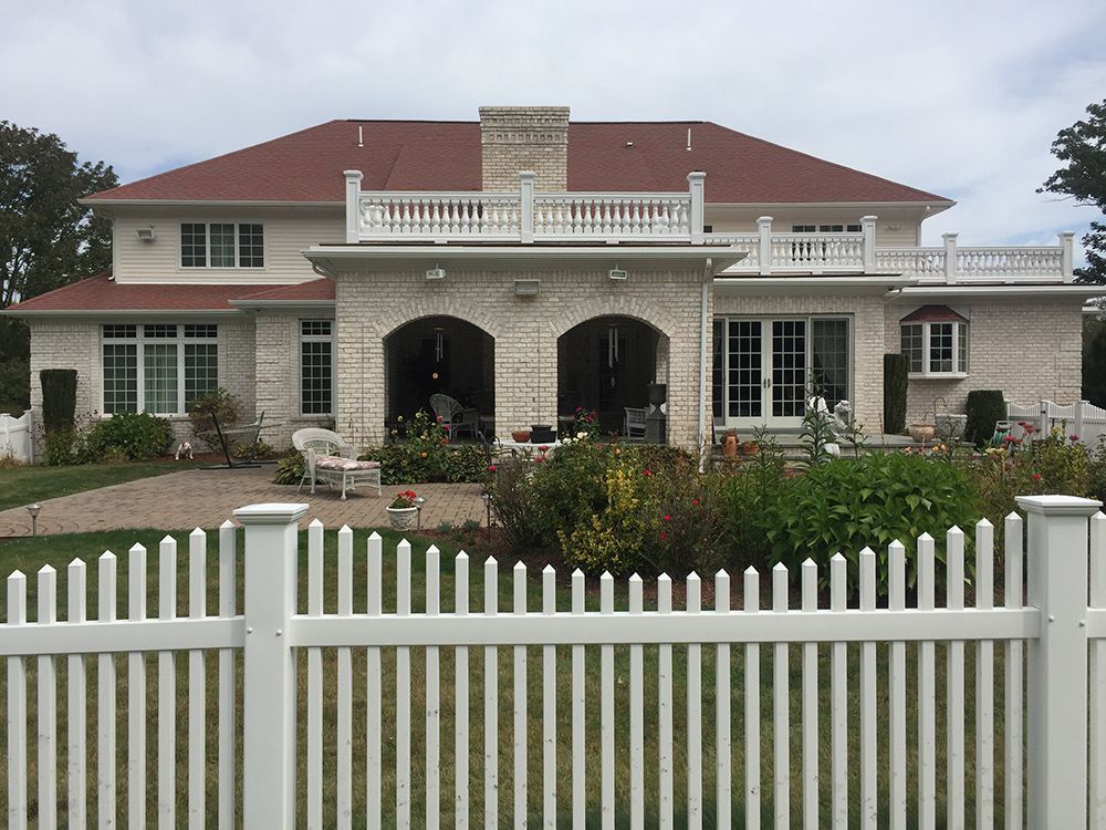 A large white house with a white picket fence in front of it