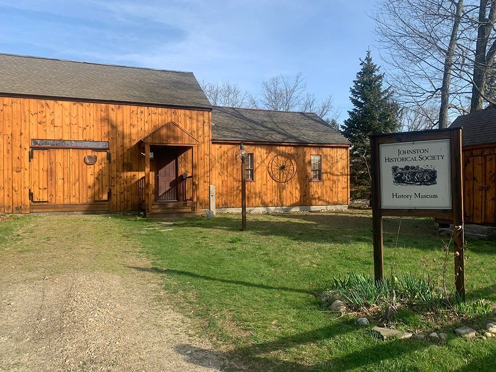 A wooden building with a sign in front of it.