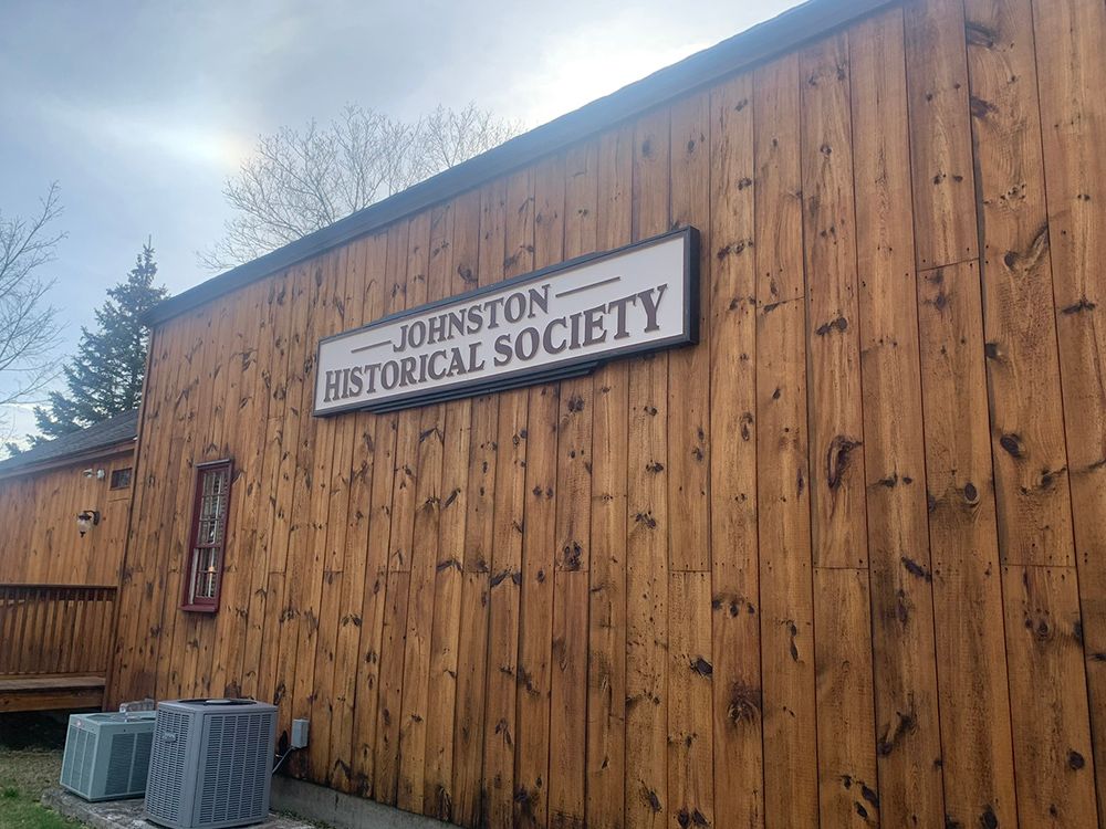 A wooden building with a sign that says johnston historical society
