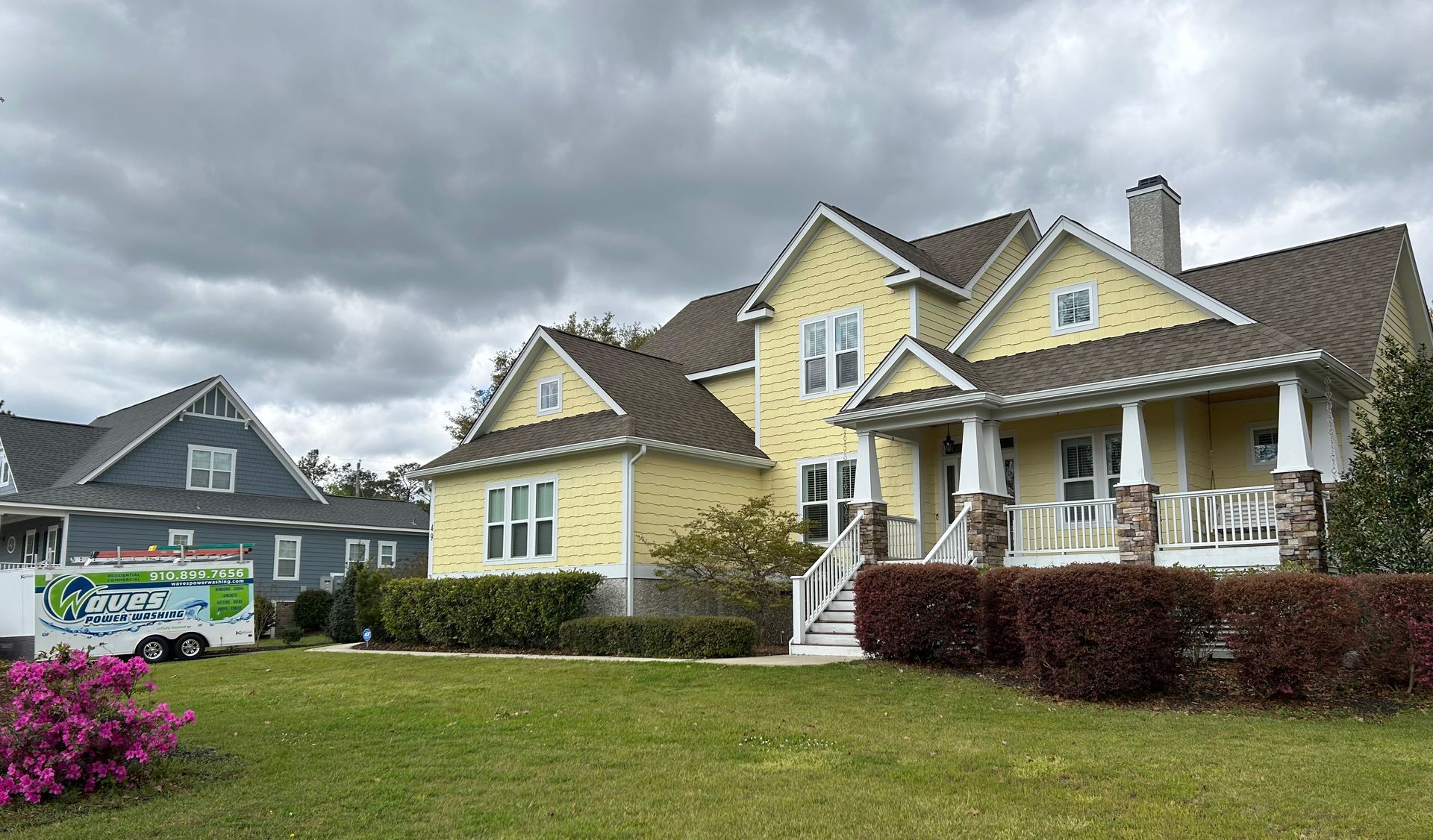 A large yellow house with a truck parked in front of it.