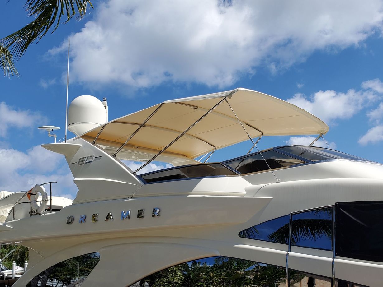 A boat with a canopy on top of it is parked in front of a house.