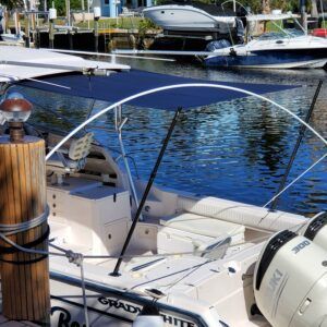 A boat with a canopy is docked at a marina.
