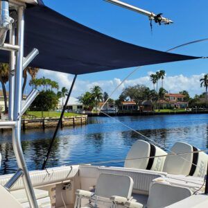A boat with a blue umbrella on top of it is floating on top of a body of water.