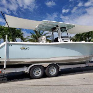 A boat is parked on a trailer with a sail.
