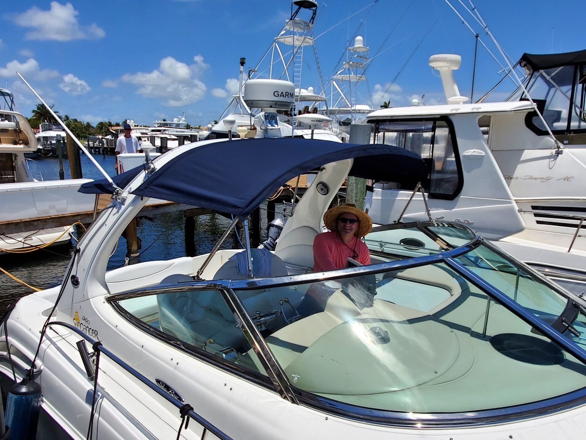 A woman is sitting on a boat with a blue canopy