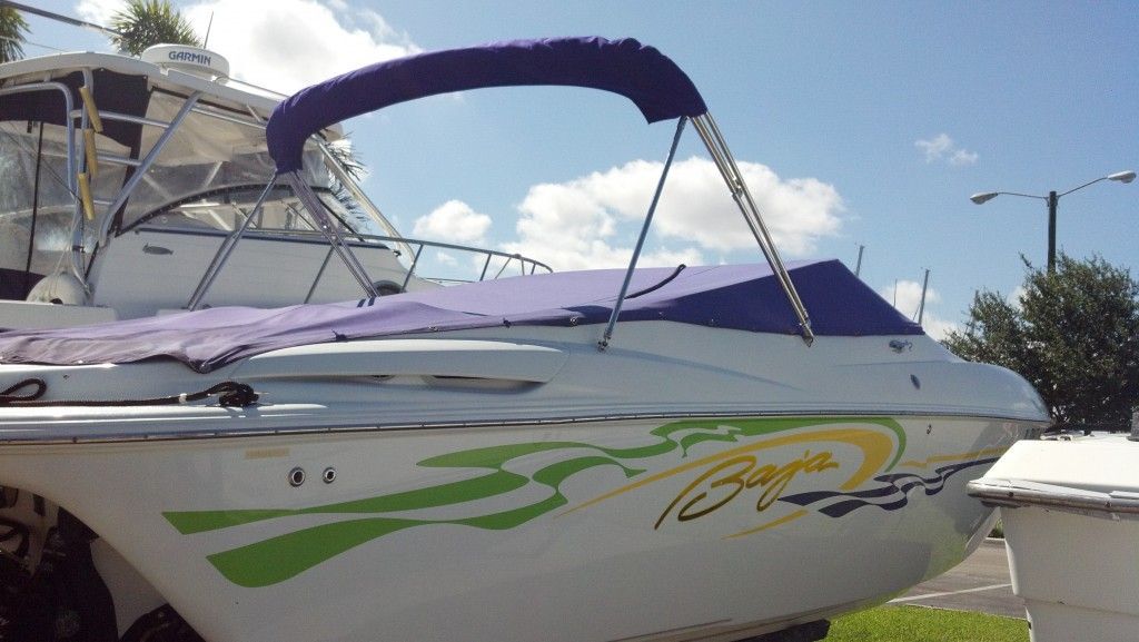 A white boat with green flames and a purple canopy