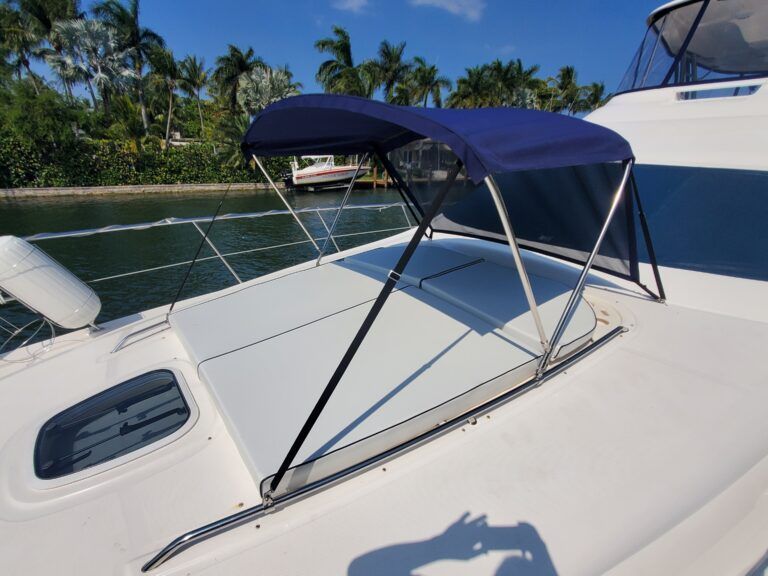 A white boat with a blue canopy on top of it