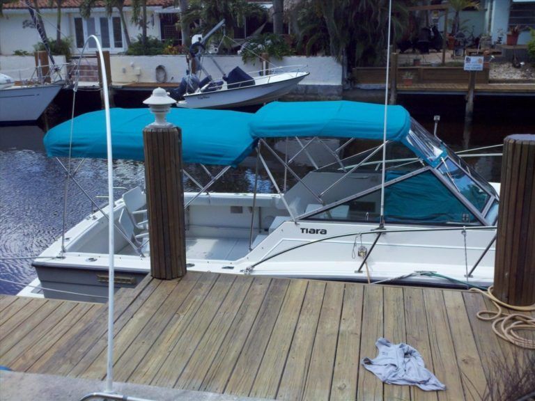 A boat with a blue canopy is docked at a dock