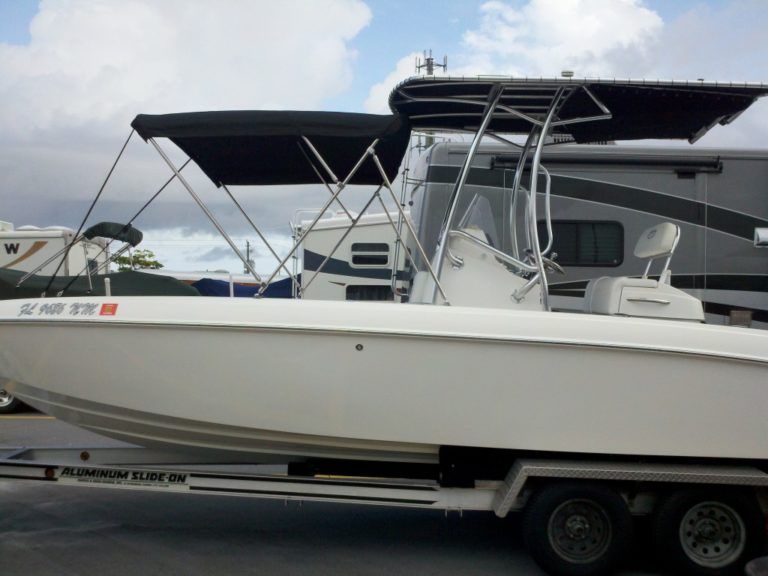 A white boat with a black canopy on top of it