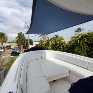 A white boat with a blue umbrella on top of it