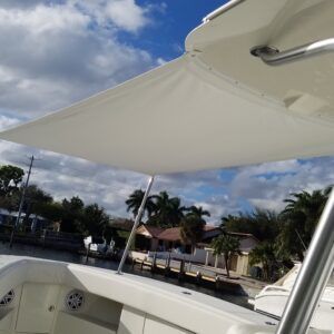 A white boat with a white canopy on top of it.