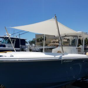 A boat with a sail on top of it is docked in a marina.