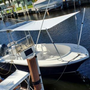 A boat with a canopy is docked in the water.