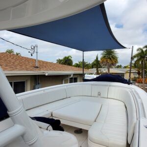 A white boat with a blue umbrella on top of it