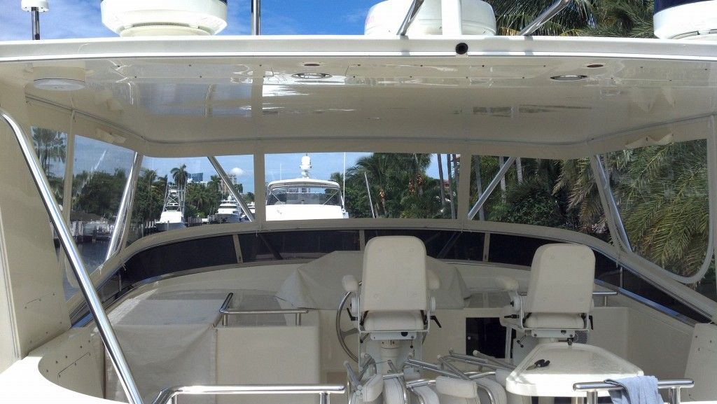The inside of a boat with a steering wheel and chairs