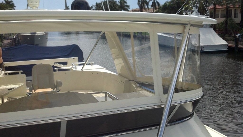 A boat with a clear windshield is in the water