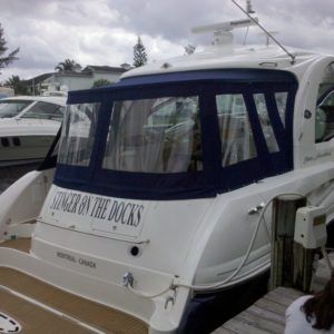 A white boat with the name stranger on the docks on the back