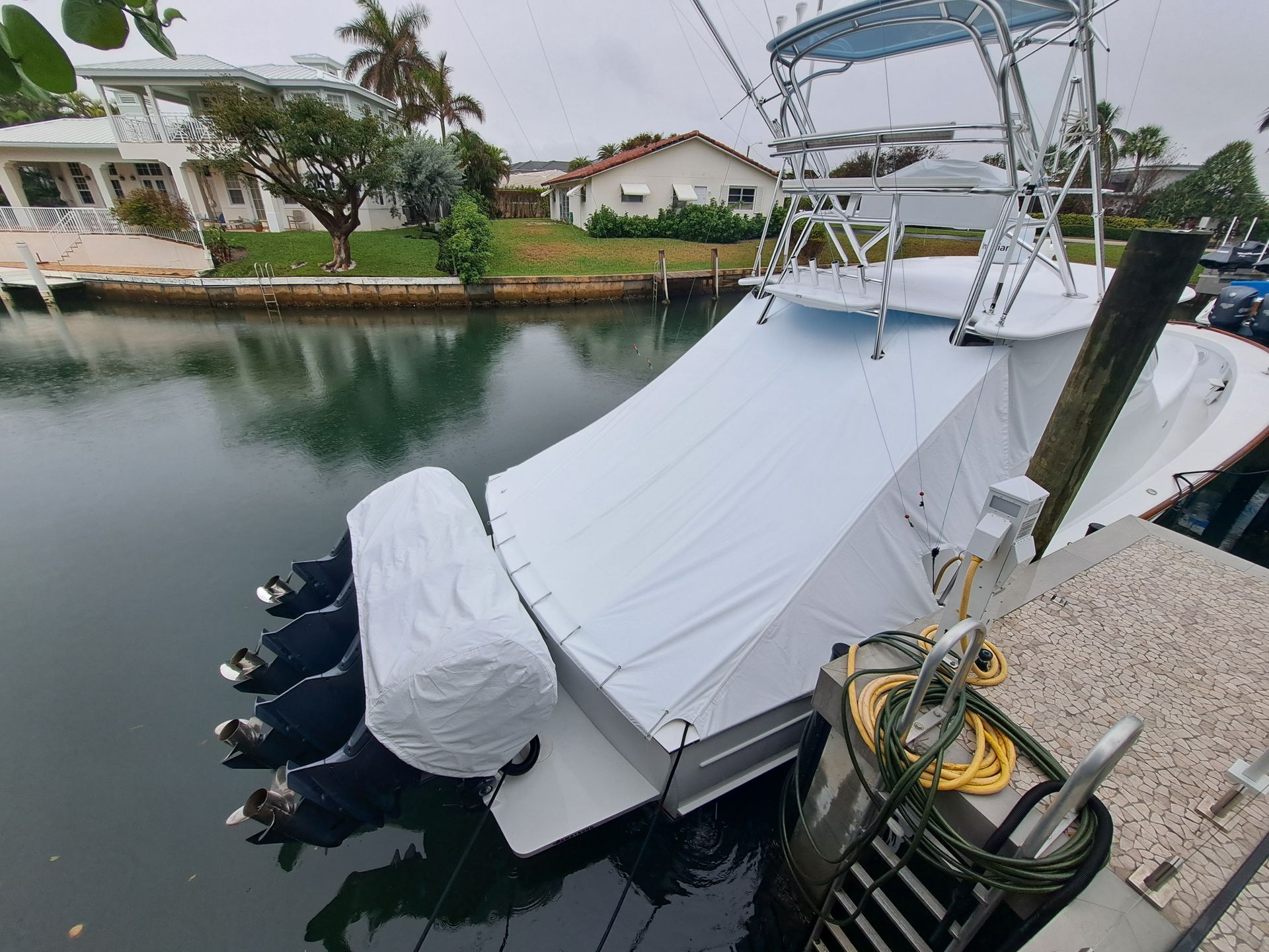 A boat with a white cover on it is docked in the water.