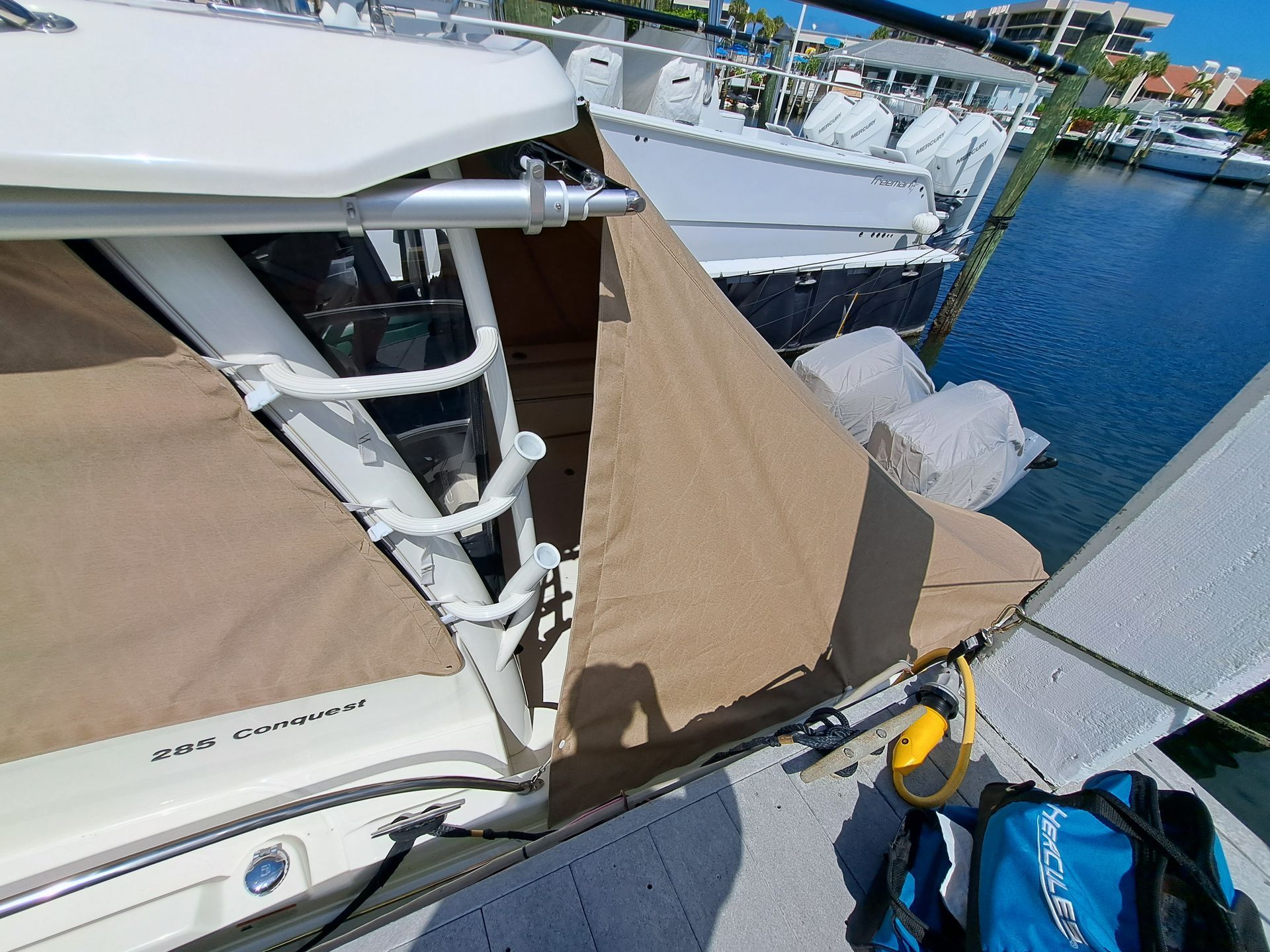 A boat with a tent on top of it is docked in a marina.
