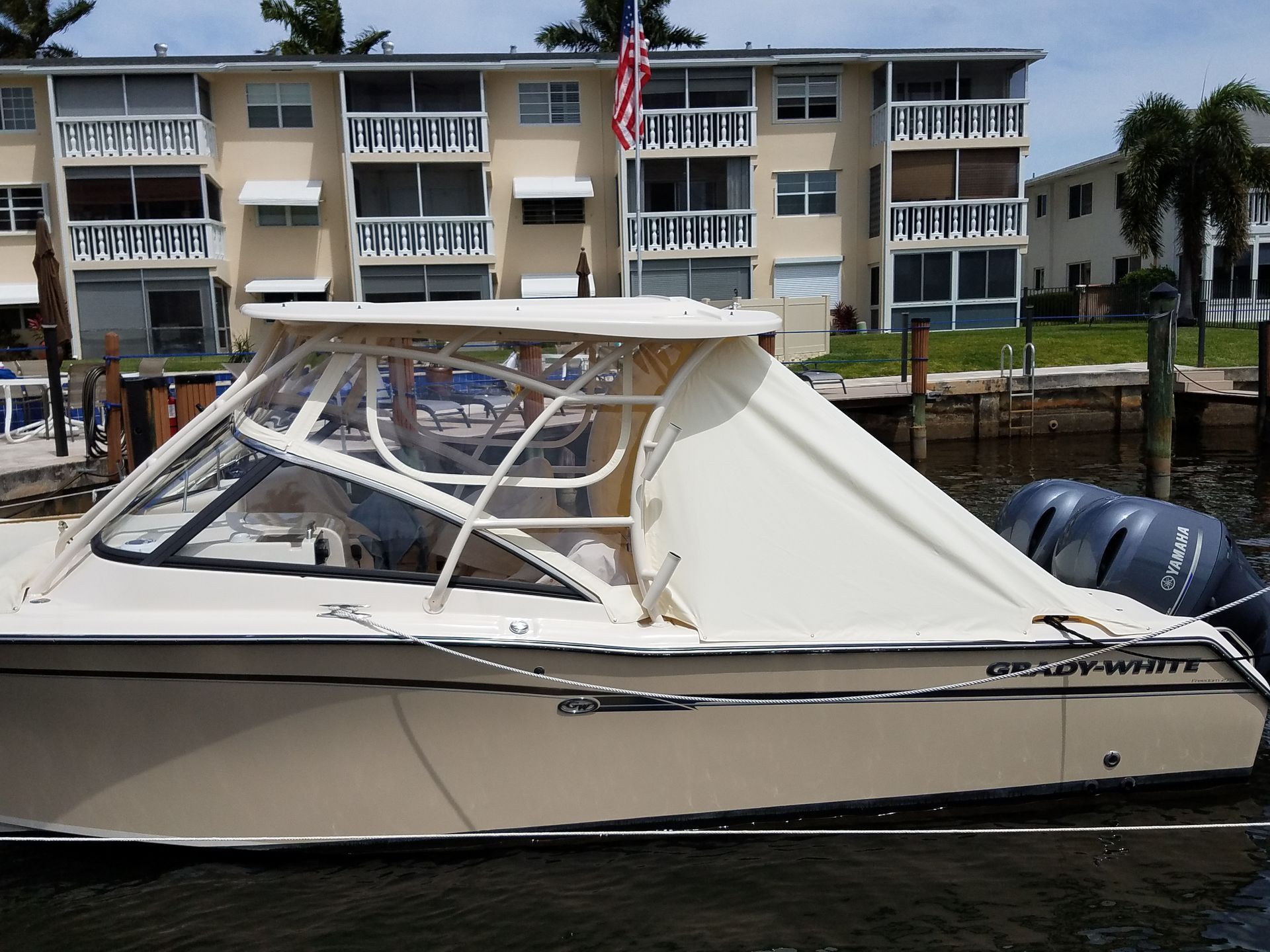A boat is docked in front of a building with balconies