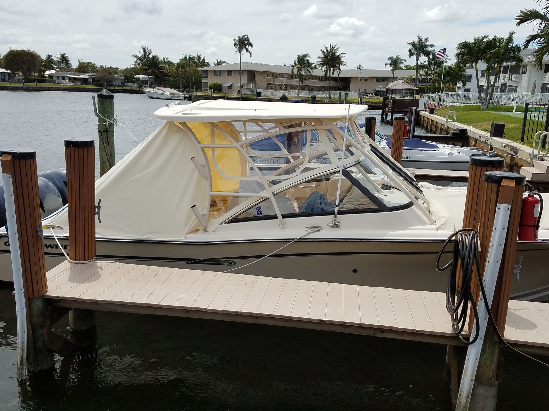 A boat with a yellow canopy is docked at a dock