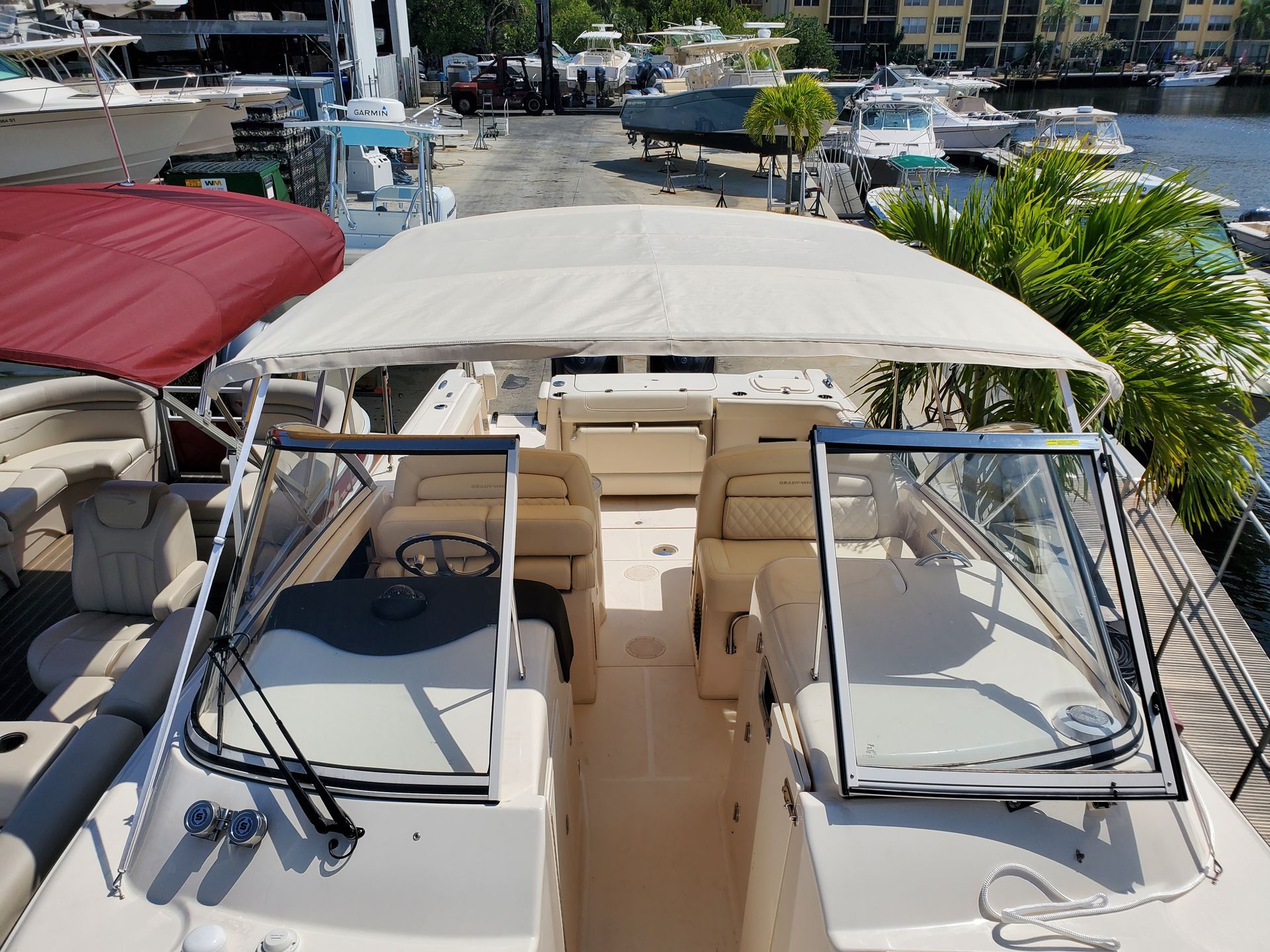 A boat with a red canopy is docked in a marina.